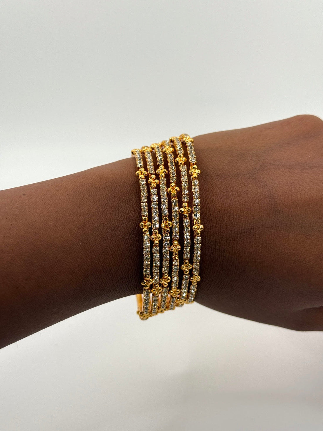 Multicolor cubic zirconia gold-plated bangle stack worn on the wrist