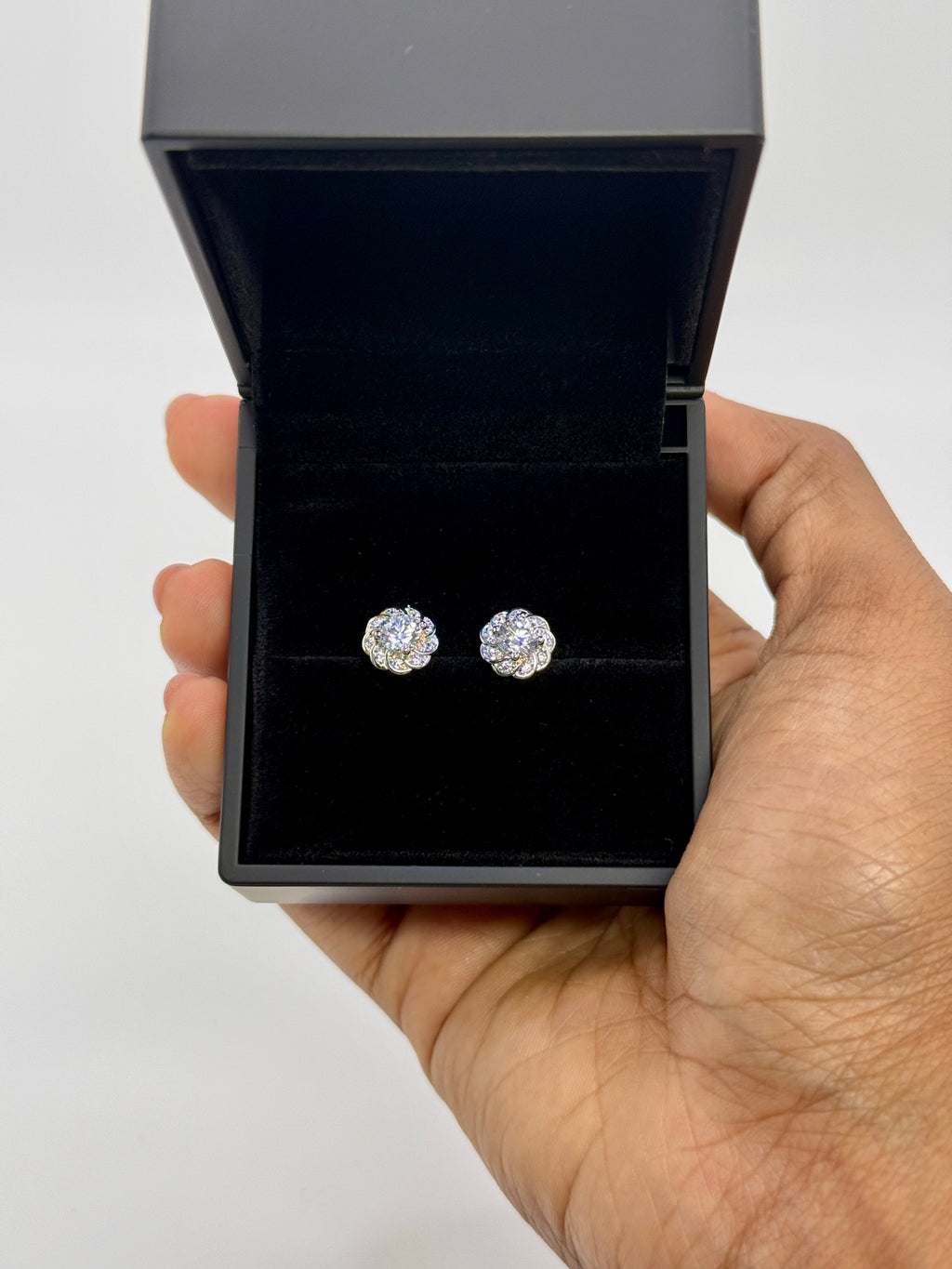 Silver-tone cubic zirconia floral stud earrings, close-up detail