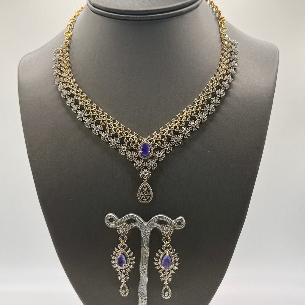 Layered gold-plated cubic zirconia necklace and earring set in royal purple, close-up detail