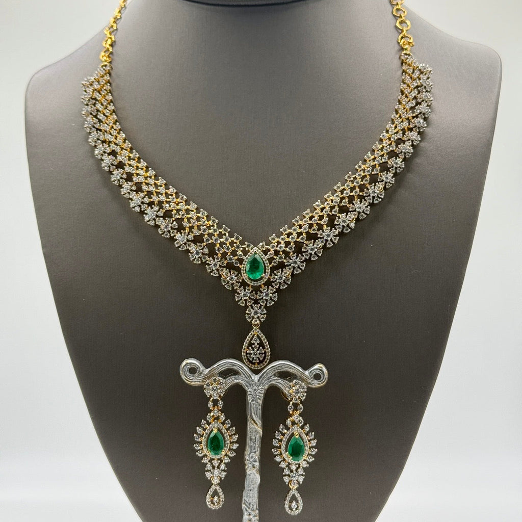 Layered gold-plated cubic zirconia necklace and earring set in emerald green, close-up detail