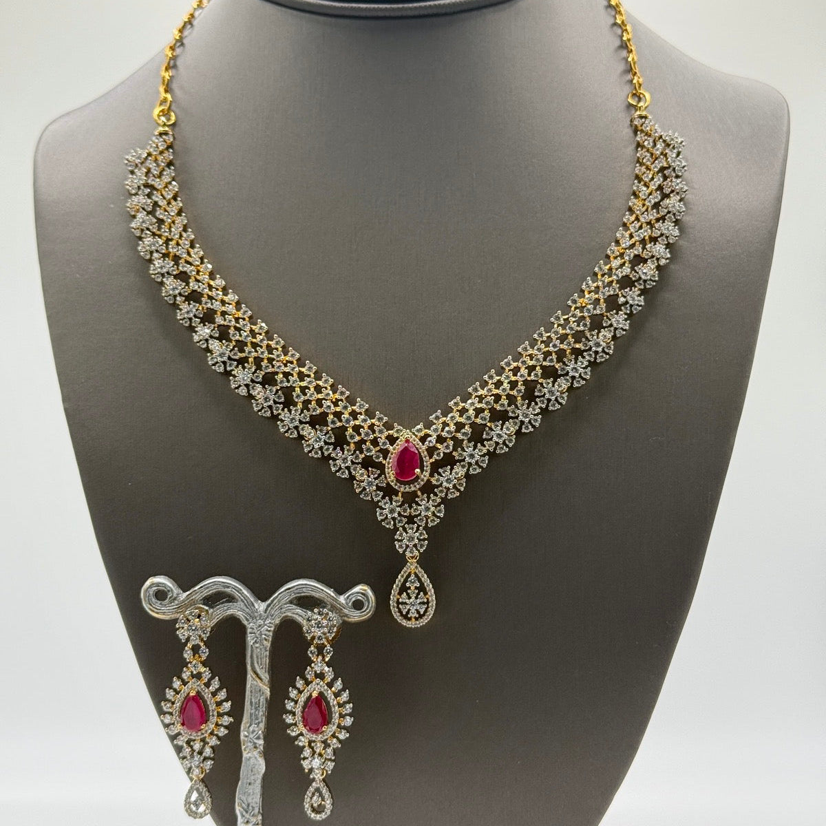 Layered gold-plated cubic zirconia necklace and earring set in ruby red, close-up detail